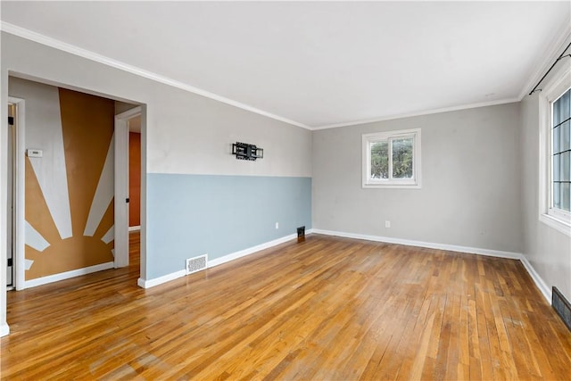 spare room with ornamental molding and light wood-type flooring