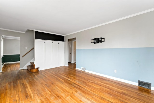 empty room featuring hardwood / wood-style floors and ornamental molding