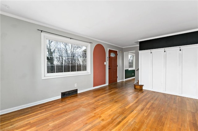 entryway featuring crown molding and light hardwood / wood-style floors