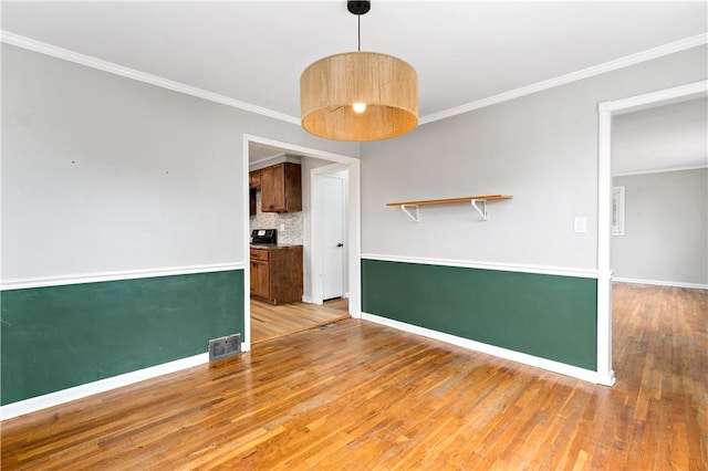 spare room featuring hardwood / wood-style flooring and ornamental molding