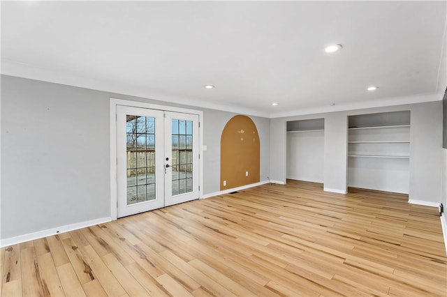 unfurnished bedroom with ornamental molding, access to outside, french doors, multiple closets, and light wood-type flooring