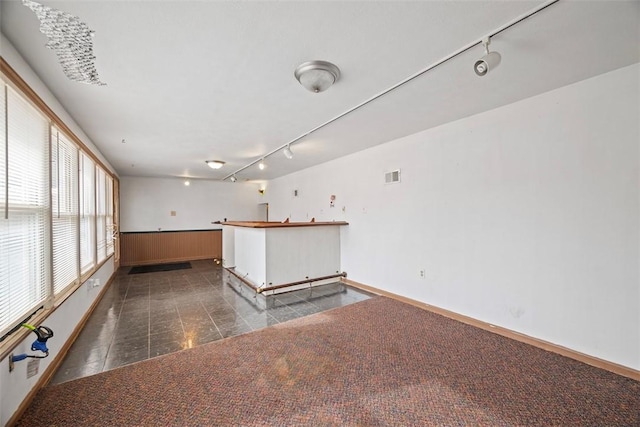 spare room with dark tile patterned flooring and track lighting