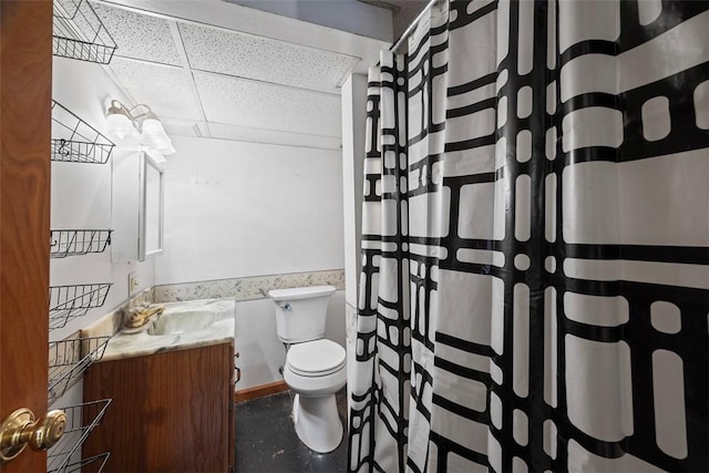 bathroom featuring a drop ceiling, vanity, and toilet