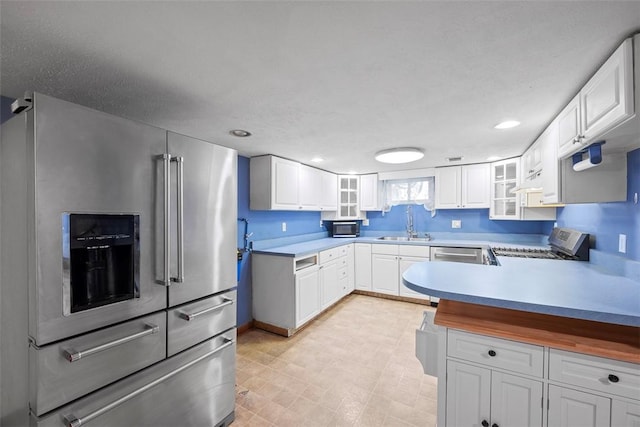 kitchen with stainless steel appliances, sink, and white cabinets