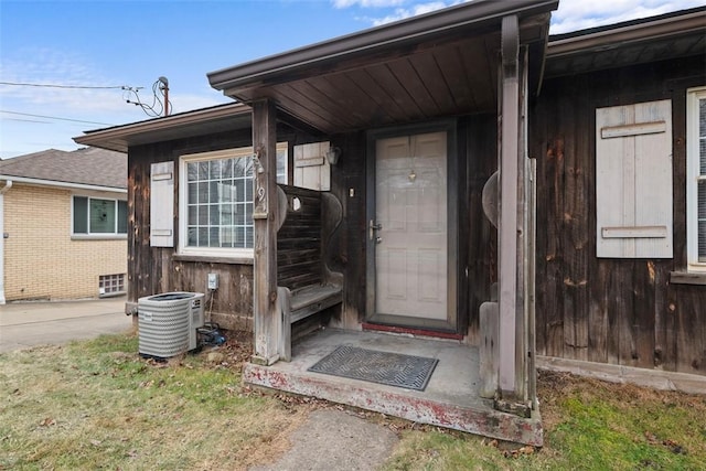 entrance to property with central AC and a lawn