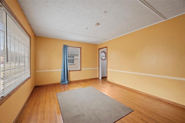 spare room with hardwood / wood-style flooring, a healthy amount of sunlight, and a textured ceiling