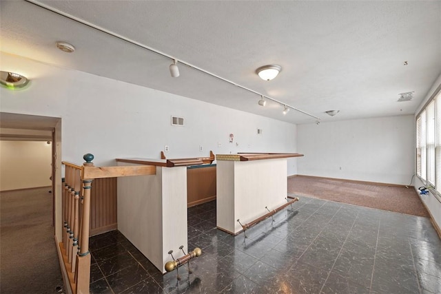 kitchen with a center island, track lighting, and a textured ceiling