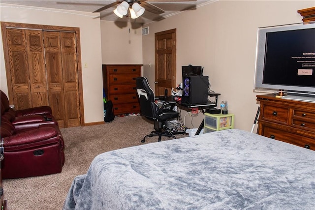 carpeted bedroom with crown molding, ceiling fan, and a closet