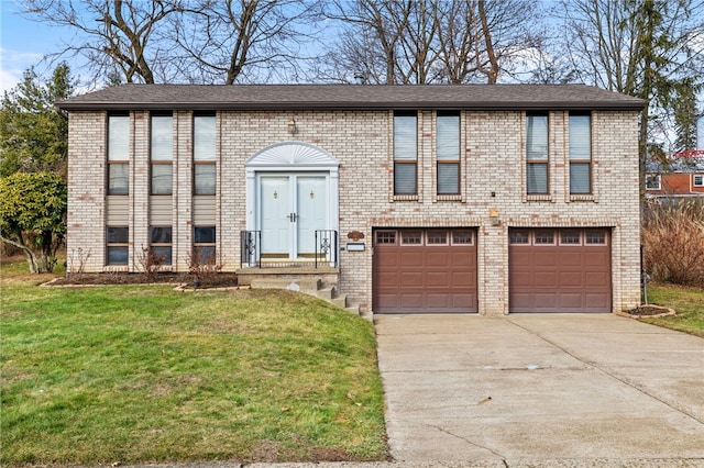 bi-level home featuring a garage and a front lawn