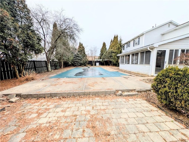 view of swimming pool with a sunroom and a patio area