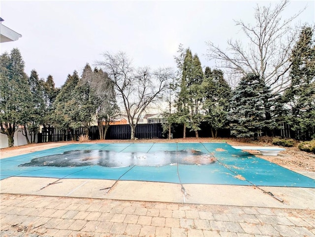 view of swimming pool with a diving board