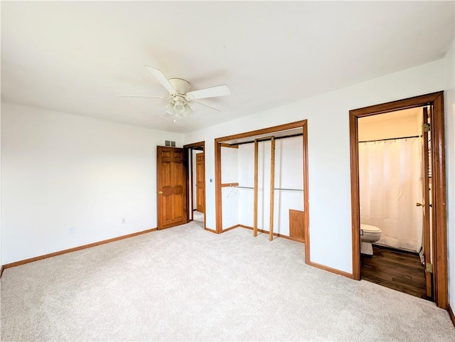 unfurnished bedroom with light carpet, ensuite bath, a closet, and ceiling fan