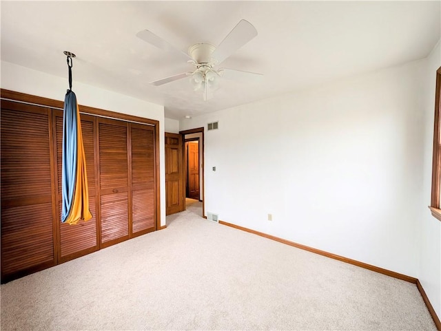 unfurnished bedroom with two closets, ceiling fan, and carpet flooring