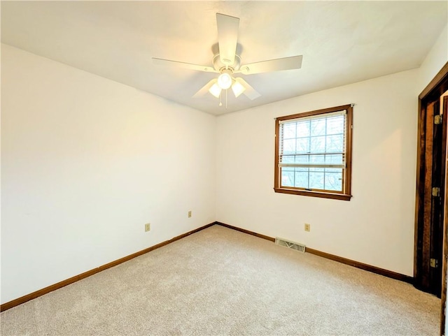 carpeted spare room featuring ceiling fan