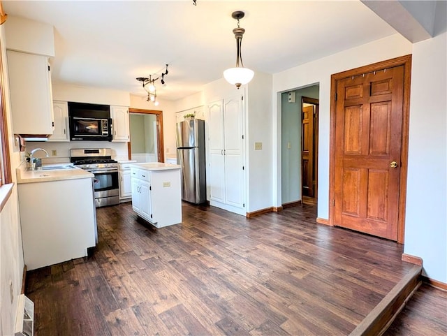 kitchen with a kitchen island, dark hardwood / wood-style floors, pendant lighting, white cabinetry, and stainless steel appliances