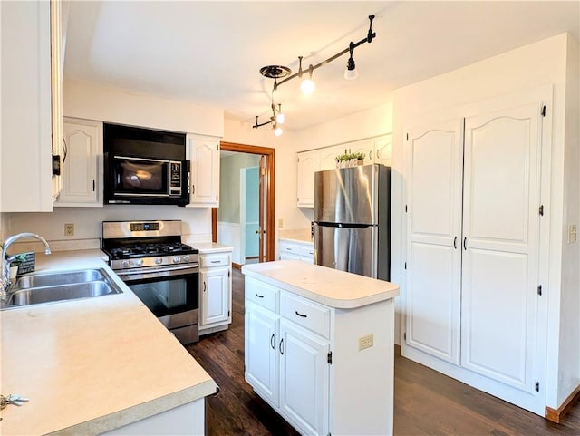 kitchen with white cabinetry, sink, dark hardwood / wood-style flooring, a center island, and stainless steel appliances