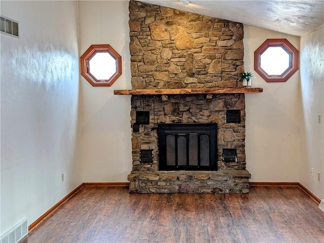 unfurnished living room featuring hardwood / wood-style flooring, vaulted ceiling, and a fireplace