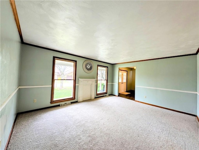 carpeted spare room featuring crown molding