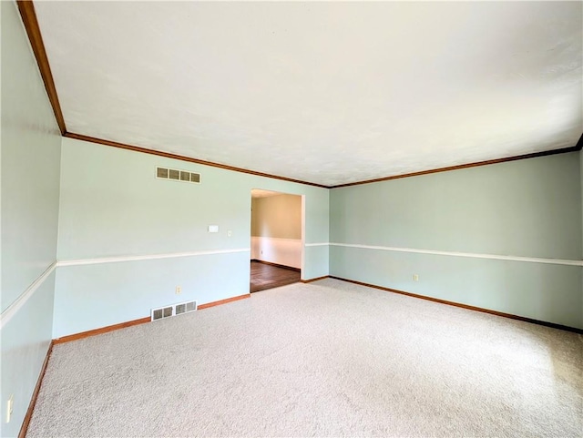 spare room with ornamental molding and carpet