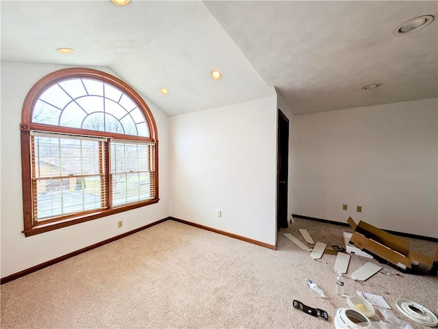 empty room with light carpet and vaulted ceiling