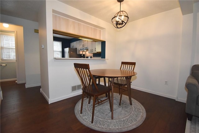 dining area featuring a notable chandelier and dark hardwood / wood-style floors