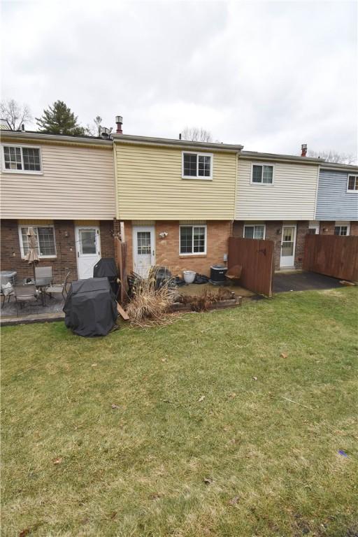 rear view of house with a yard, a patio area, and central air condition unit