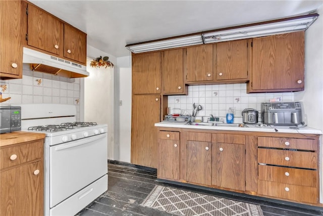 kitchen featuring sink, decorative backsplash, and gas range gas stove