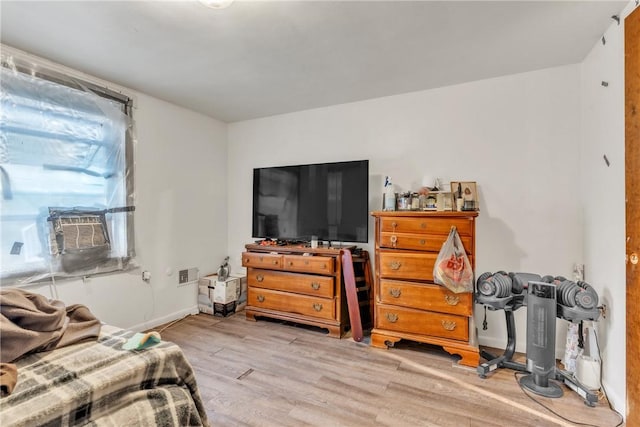 bedroom with cooling unit and light wood-type flooring