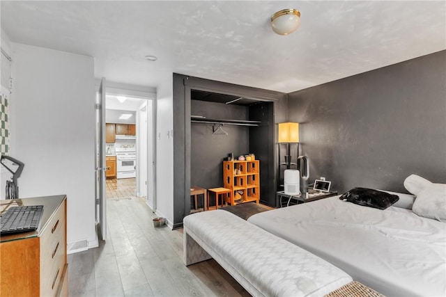 bedroom with light wood-type flooring and a closet