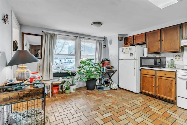 kitchen with white appliances and backsplash