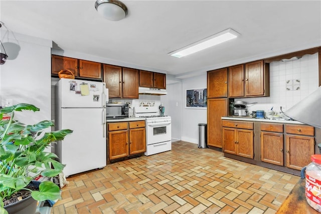 kitchen featuring tasteful backsplash and white appliances