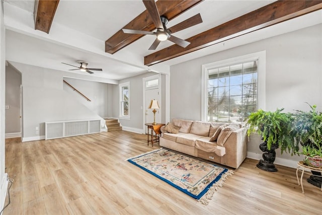 living room featuring ceiling fan, stairway, and beam ceiling