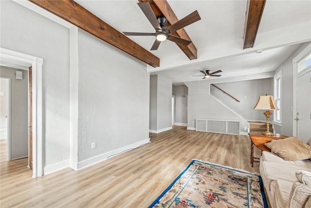 living room with beamed ceiling, visible vents, wood finished floors, and a ceiling fan