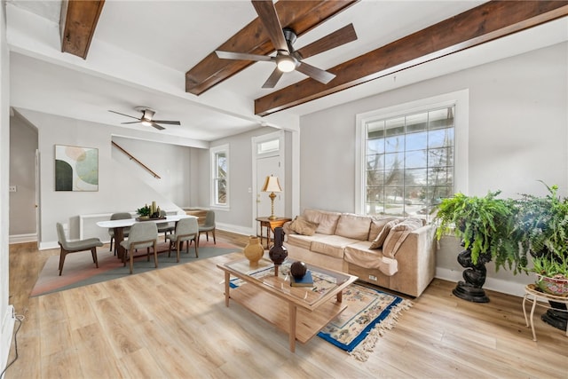 living area with beamed ceiling, wood finished floors, and ceiling fan