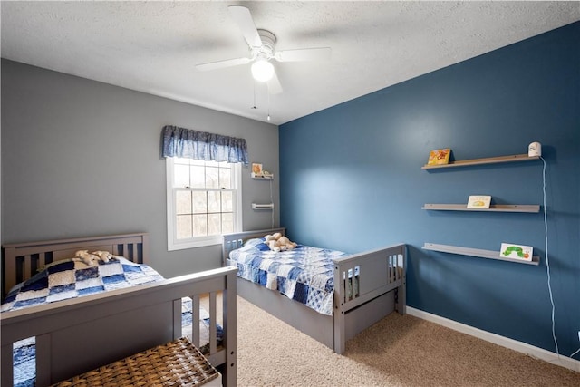 bedroom with ceiling fan, carpet, and a textured ceiling