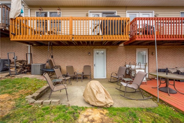 rear view of house with a wooden deck, a patio, and central air condition unit