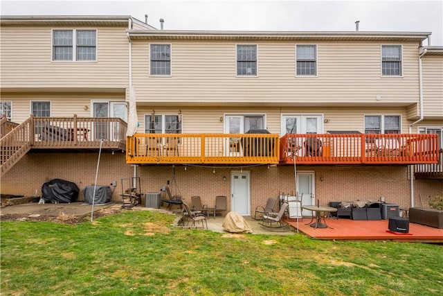 rear view of property featuring cooling unit, a patio, a deck, and a lawn