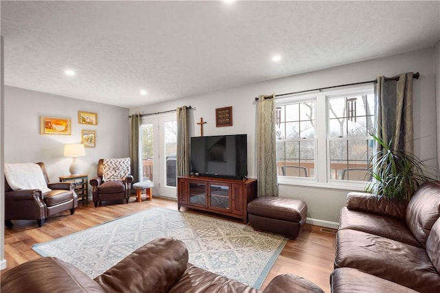 living room with light hardwood / wood-style flooring and a textured ceiling