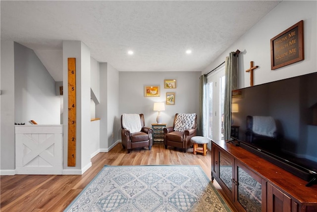 living area with a textured ceiling and light wood-type flooring