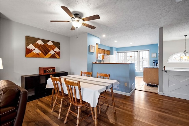 dining room with hardwood / wood-style flooring, ceiling fan, and a textured ceiling