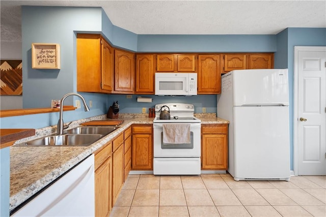 kitchen featuring light tile patterned flooring, white appliances, sink, and a textured ceiling