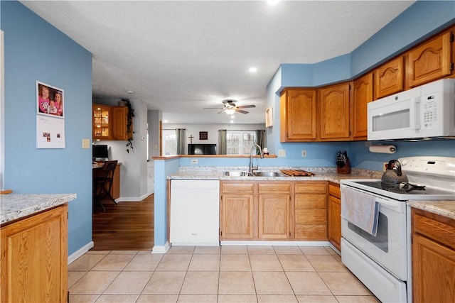 kitchen with sink, light tile patterned floors, ceiling fan, kitchen peninsula, and white appliances