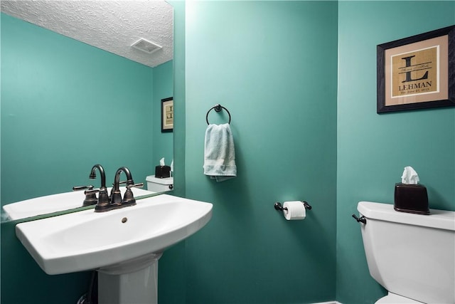 bathroom featuring sink, toilet, and a textured ceiling