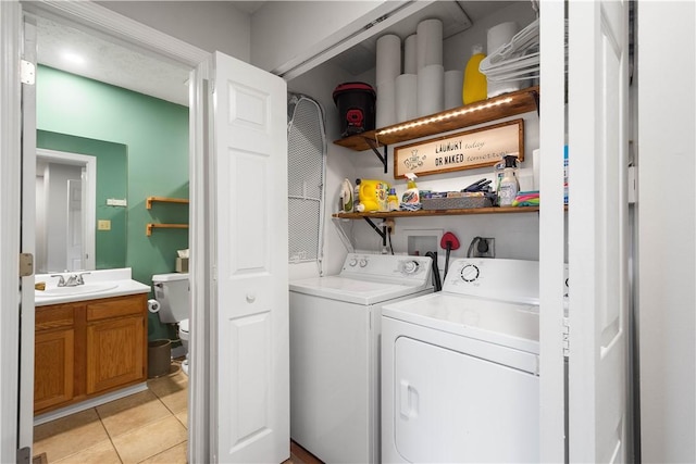 laundry room featuring light tile patterned flooring, independent washer and dryer, and sink