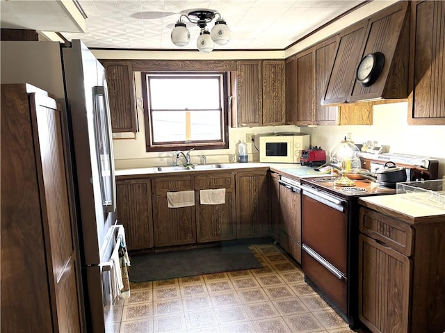 kitchen with dark brown cabinetry, black / electric stove, sink, and extractor fan