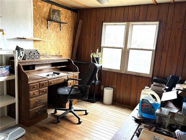 office area featuring plenty of natural light, wooden walls, and light hardwood / wood-style flooring