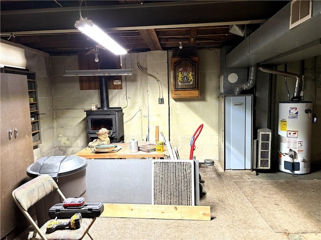 basement featuring a wood stove and gas water heater