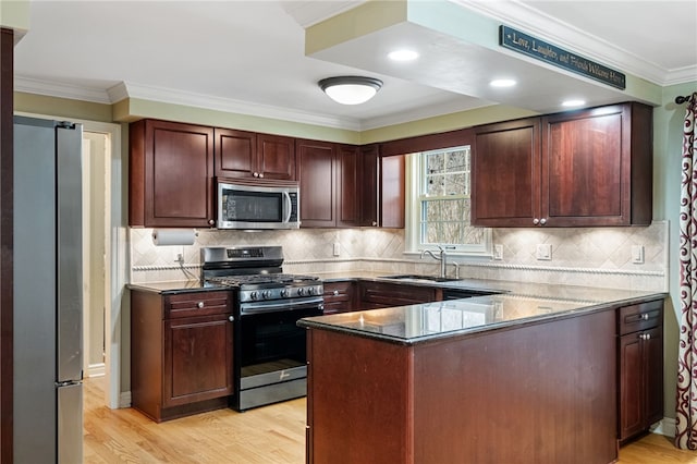 kitchen with sink, appliances with stainless steel finishes, ornamental molding, kitchen peninsula, and light wood-type flooring