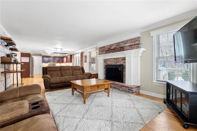 living room featuring crown molding, a brick fireplace, and light hardwood / wood-style flooring