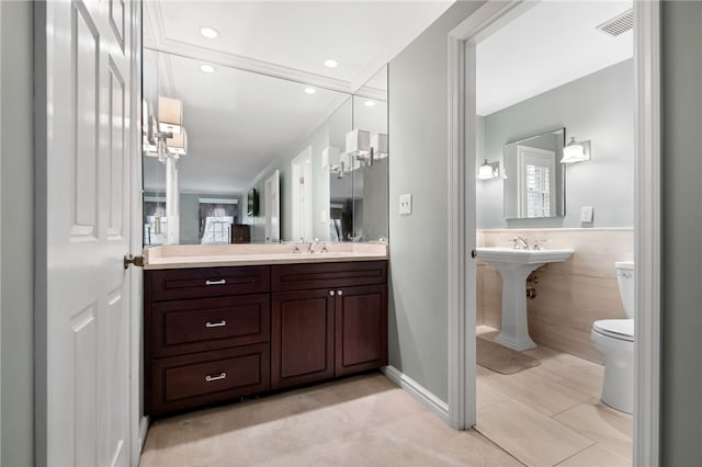 bathroom with tile patterned floors, toilet, sink, and tile walls